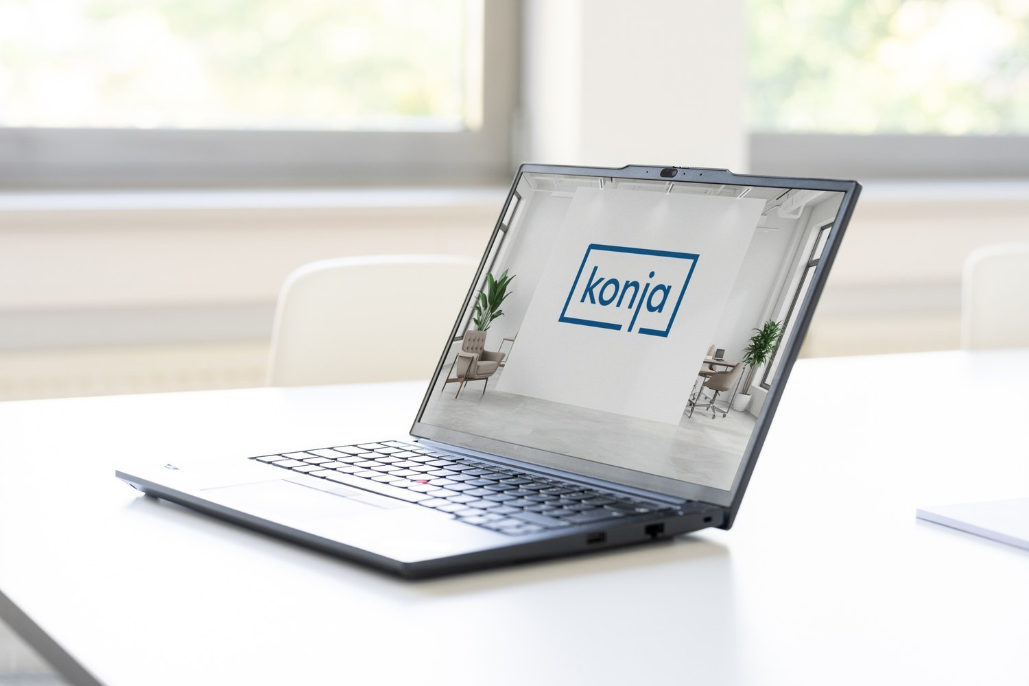 Laptop mit konja-Logo auf einem weißen Besprechungstisch.